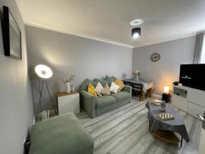 a living room with a green couch and a table at City Life Access Everywhere in London