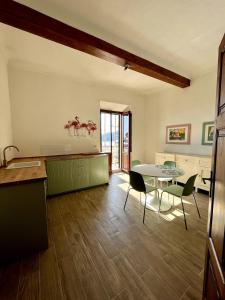 Una cocina y un comedor con mesa y sillas. en Il Fenicottero - Cozy apartment with view, en Porto Santo Stefano