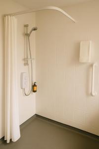 a shower with a shower curtain in a bathroom at Lytton Tree Lodge Self-Catering Garden Lodges - Near Southwold in Reydon +36 photos