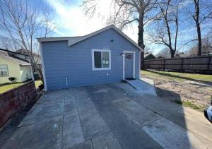una casa con un garage blu in un cortile di Brand New Bungalow with Amenities a Tulsa