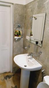 Un baño con un lavabo blanco y un espejo. en Ambuluwava Eco Resort, en Gampola 5 fotos más
