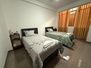 une chambre avec deux lits et une fenêtre dans l'établissement Estancia Luz y Armonía, à Casma
