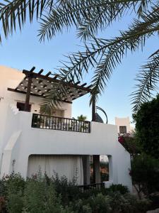 Casa blanca con balcón y palmeras en Delta Sharm Casa, en Sharm El Sheikh