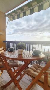 a wooden table on a balcony with a view of the ocean at Lookout Point Tenerife Holiday Apartment Las Americas in Playa Fañabe