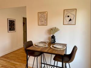 a dining room table with two chairs and a table with plates at Le Nid Cosy, studio in Saint Die