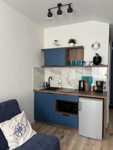 a small kitchen with blue cabinets and a sink at Blue Apartment B, Dębina in Debina
