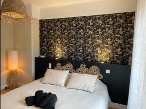 sypialnia z łóżkiem z czarno-białym zagłówkiem w obiekcie Le Nid Cosy, studio w mieście Saint-Dié +4 zdjęcia