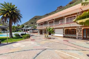 モガンにあるLos Peñones Experienceのヤシの木と建物のあるリゾート