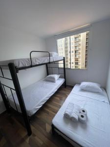 deux lits superposés dans une chambre avec fenêtre dans l'établissement Acogedor apartamento, à Estación El Salto