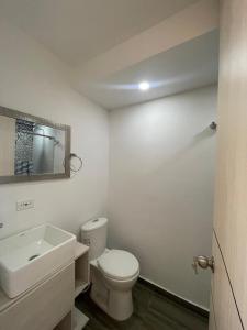 une salle de bain avec des toilettes blanches et un lavabo dans l'établissement Acogedor apartamento, à Estación El Salto
