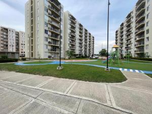 - une aire de jeux dans un complexe d'appartements avec de grands bâtiments dans l'établissement Acogedor apartamento, à Estación El Salto