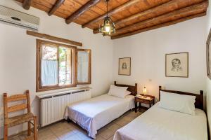 una camera da letto con due letti e una finestra di Natalia's Houses a Chania