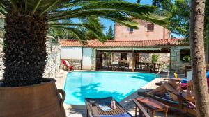 una donna sdraiata sulle sedie accanto alla piscina di Natalia's Houses a Chania