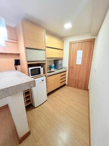 a small kitchen with a counter and a refrigerator at Apart Vista Azul - hospedagem nas montanhas in Domingos Martins