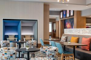 a restaurant with tables and chairs and a couch at Tru By Hilton Houston Downtown Convention Center in Houston