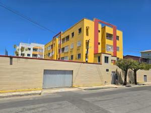 a yellow and red building on the side of a street at Tesouro da Maraponga in Fortaleza