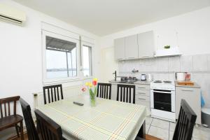 a kitchen with a table with a vase of flowers on it at Vila Popović Plaža in Kladovo
