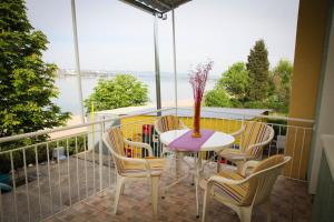 a table and chairs on a balcony with a view of the water at Vila Popović Plaža in Kladovo