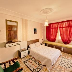 a bedroom with a bed and a red window at Guest house DARNART Hostel in Aourir