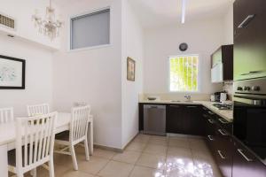 Una cocina con una mesa y sillas en una habitación. en Spacious 2BR Apartment with 2 Bathrooms, Living Room & Kitchen - Prime LocationNear ddizengoff st, en Tel Aviv