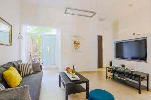 Una sala de estar con un sofá y un televisor de pantalla plana. en Spacious 2BR Apartment with 2 Bathrooms, Living Room & Kitchen - Prime LocationNear ddizengoff st, en Tel Aviv