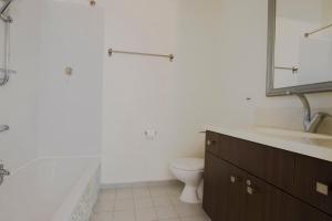 Un baño con inodoro, lavabo y espejo. en Spacious 2BR Apartment with 2 Bathrooms, Living Room & Kitchen - Prime LocationNear ddizengoff st, en Tel Aviv