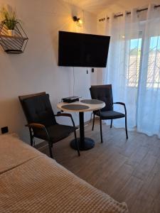a room with a table and two chairs and a tv at Apartmani Goga - Molat 6 in Molat