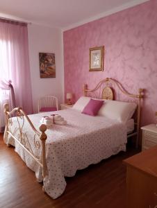 a bedroom with a white bed with pink walls at CASA LEBRà in Force