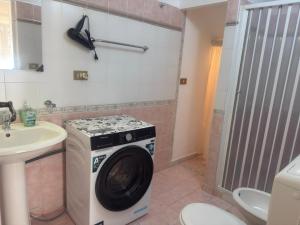 a washing machine in a bathroom with a sink at Arco Apartment in Bagheria