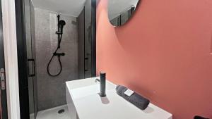 une salle de bain avec un lavabo blanc et une douche dans l'établissement Le Petit Niçois, à Nice