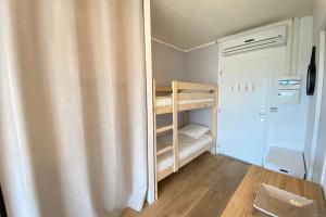 a small room with bunk beds and a refrigerator at Lovely 4-person studio - pool and sea in Saint-Laurent-du-Var