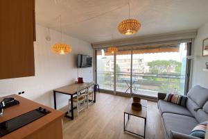 a living room with a couch and a table at Lovely 4-person studio - pool and sea in Saint-Laurent-du-Var