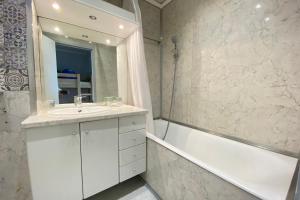 a bathroom with a sink and a tub and a mirror at Lovely 4-person studio - pool and sea in Saint-Laurent-du-Var