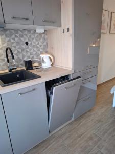 a white kitchen with a sink and a counter at Apartmani Goga - Molat 6 in Molat