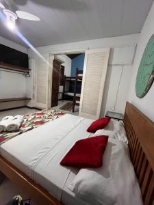 a bedroom with a large bed with red pillows at Pousada Mandala - Búzios in Búzios