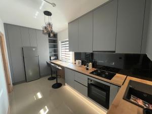 a kitchen with white cabinets and a stove top oven at AGM Home in Cajvana