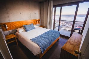 una camera da letto con un letto e vista sull'oceano di Apart Hotel Kudun a Pichilemu
