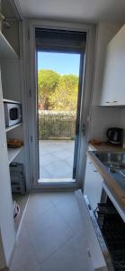 Cabestan air-conditioned Marina opposite the shops near the North Beach في لو غراو دو روا: مطبخ مع باب يؤدي إلى الفناء