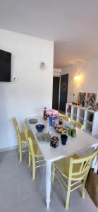 Cabestan air-conditioned Marina opposite the shops near the North Beach في لو غراو دو روا: طاولة طعام بيضاء مع كراسي صفراء وطاولة