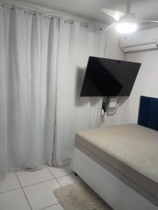 a bedroom with a bed and a tv on the wall at Só o Quarto para você! in Rio de Janeiro