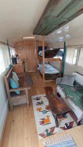 a room with two bunk beds and a rug at Rooftop Converted School Bus in San Marcos La Laguna +19 photos