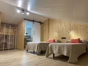 two beds in a room with wooden walls at Alma Marina Apartamentos in Somo +33 photos