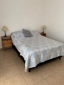 a bed in a bedroom with two nightstands and two lamps at Almirante Brown 235 PLATA ALTA D-3 in San Martín