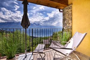 a balcony with two chairs and an umbrella at Apartment Monti e Lago - Tignale in Tignale