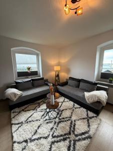 a living room with two couches and a rug at Holzkunst & Heimatgefühl in Seiffen für Familie & Freunde in Kurort Seiffen