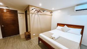 a bedroom with a bed with a towel on it at Tiwi's Travellers Inn - Solar Powered, Starlink, Scooter Rental, Palawan Tours in Puerto Princesa City
