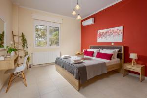 a bedroom with red walls and a bed and a desk at NeSo - Peter's Flat steps to Beach with Great Views in Kolymvari