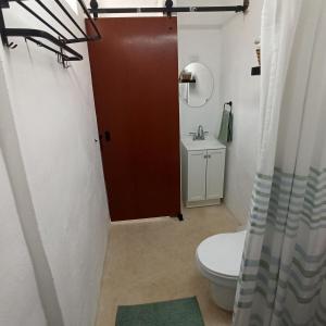 une salle de bain avec toilettes et porte rouge dans l'établissement Casa Al Mar, à Campeche