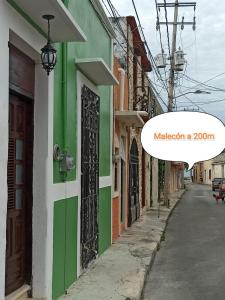 une rue avec un bâtiment vert et blanc dans l'établissement Casa Al Mar, à Campeche