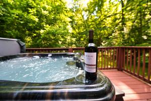 a bottle of wine is sitting in a hot tub at Smoky Mountains Hut Tub Cabin Dog Friendly in Sevierville